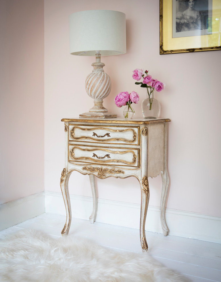 This is an example of a classic bedroom in Sussex with pink walls and painted wood flooring.