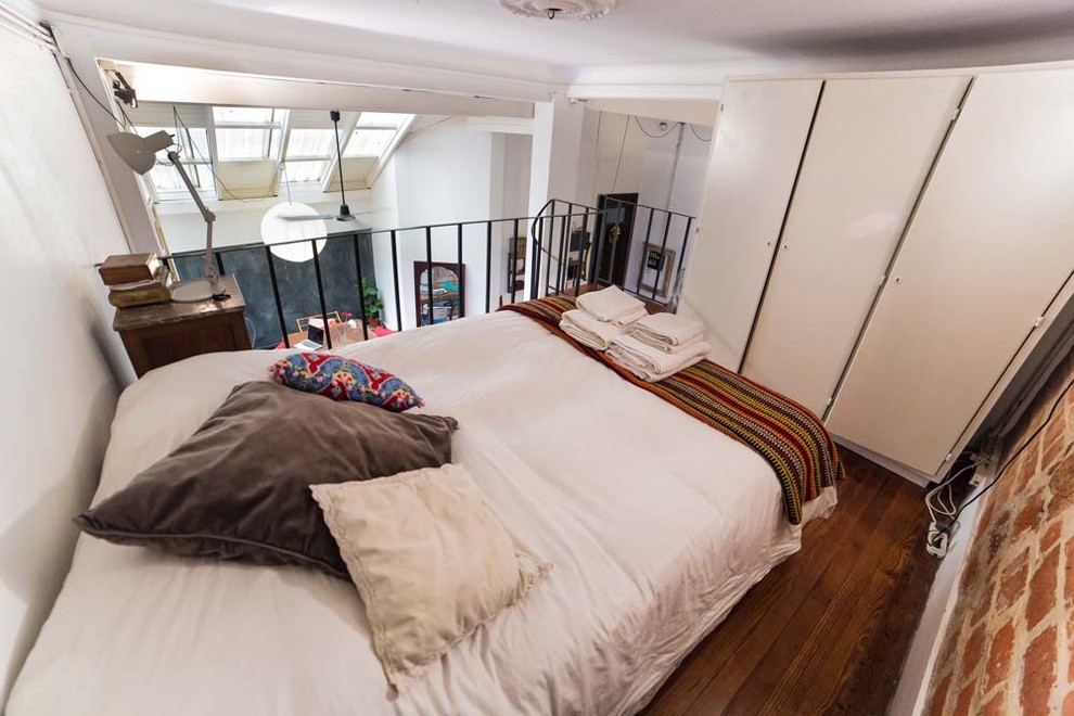 Diseño de dormitorio tipo loft de estilo americano de tamaño medio con paredes marrones, suelo de madera oscura y suelo marrón