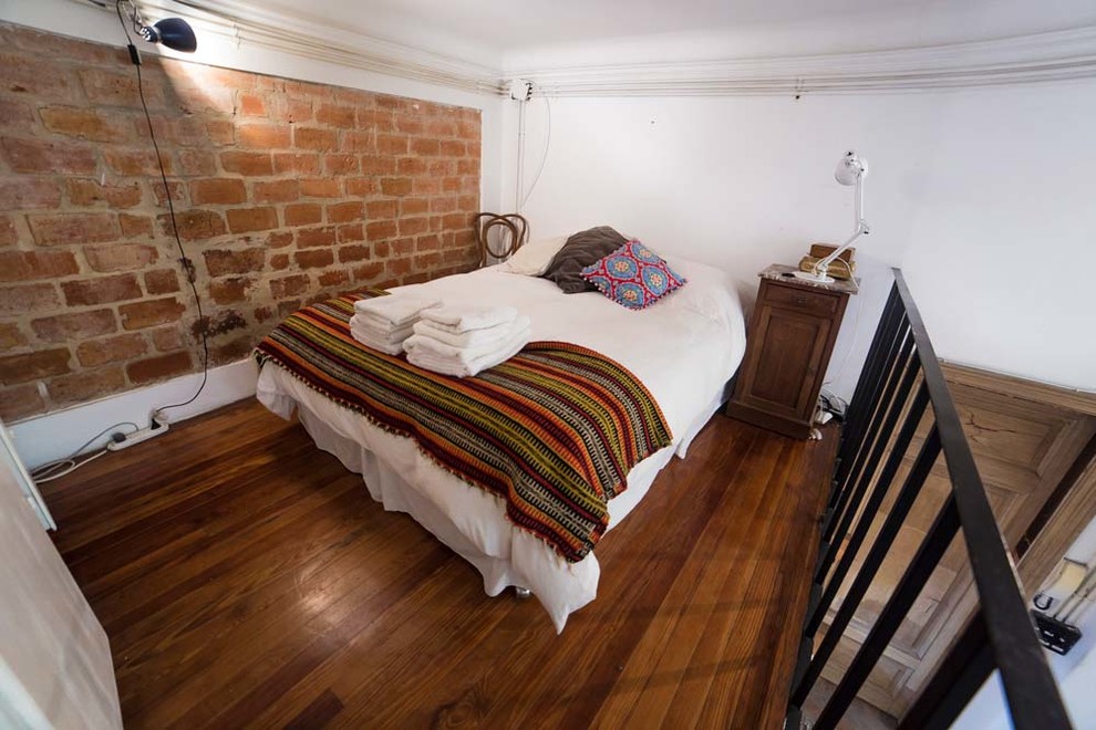 他の地域にある中くらいなトラディショナルスタイルのおしゃれなロフト寝室 (茶色い壁、濃色無垢フローリング、茶色い床)