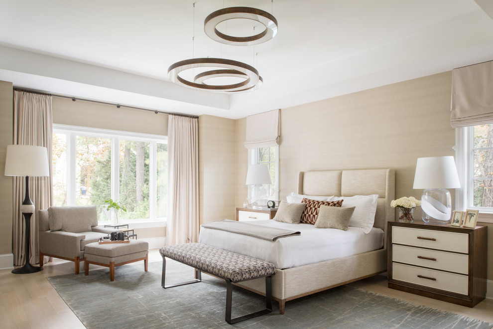 Diseño de dormitorio principal actual grande con paredes beige, suelo de madera clara y suelo beige