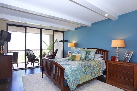 Diseño de dormitorio principal marinero con paredes azules y suelo de madera en tonos medios