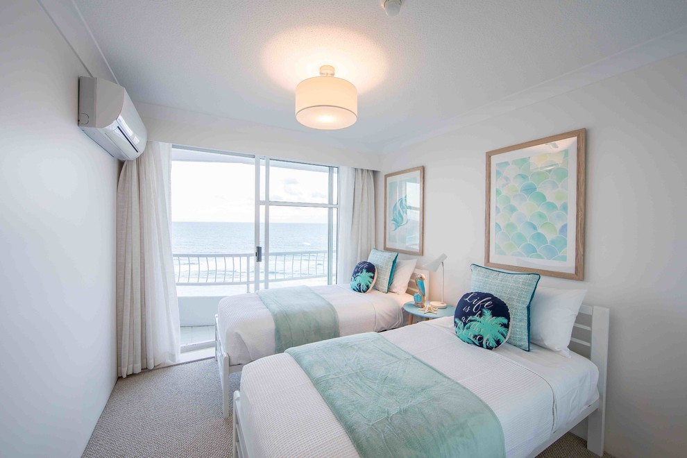 ゴールドコーストにある小さなビーチスタイルのおしゃれな客用寝室 (白い壁、カーペット敷き、ベージュの床)