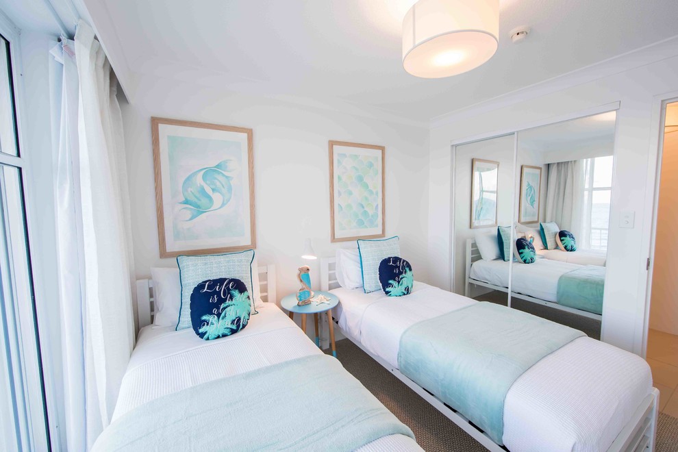 Foto de habitación de invitados costera pequeña con paredes blancas, moqueta y suelo beige