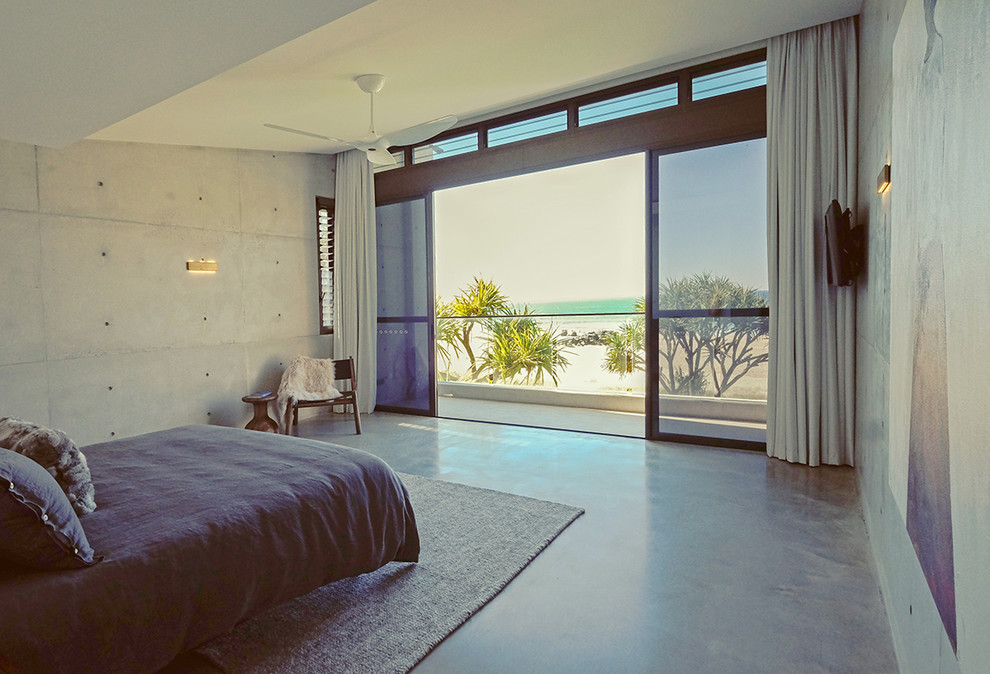 ゴールドコーストにある広いコンテンポラリースタイルのおしゃれな主寝室 (グレーの壁、コンクリートの床、暖炉なし)
