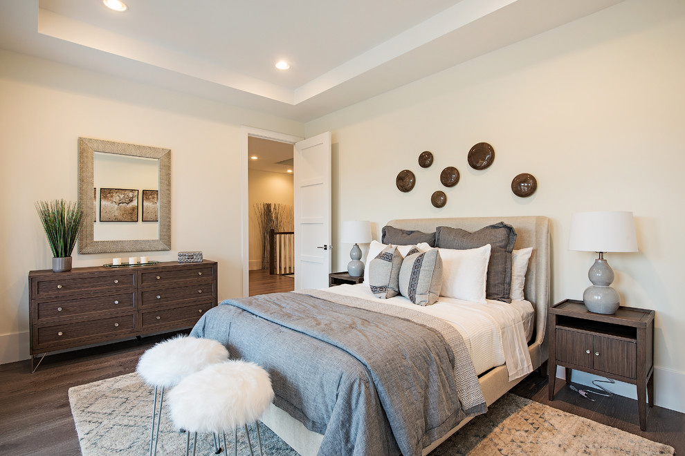 Immagine di una camera da letto chic con pareti beige e parquet scuro