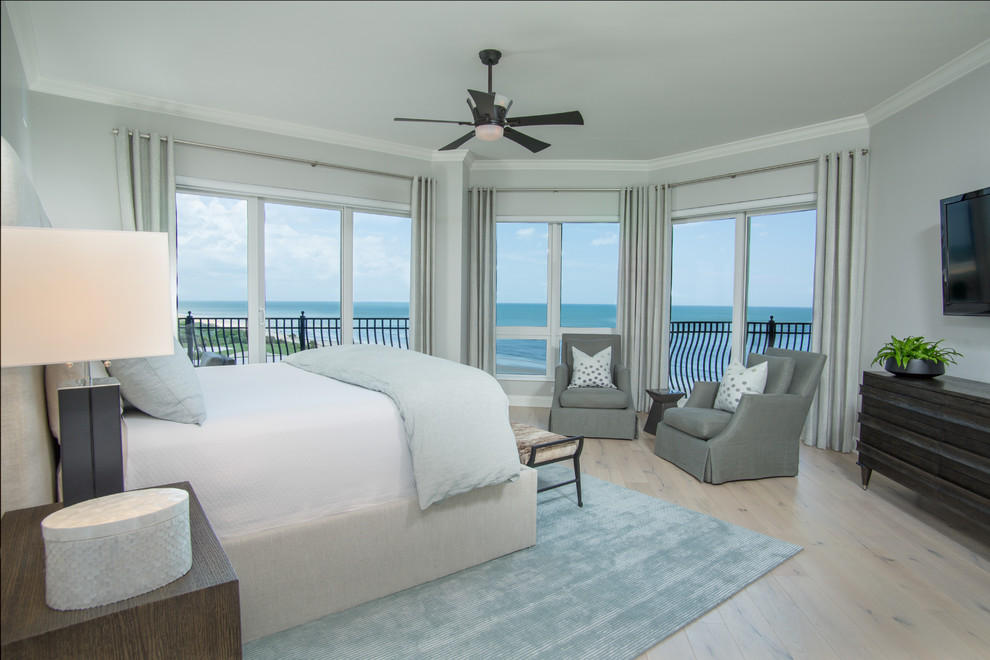 Foto de dormitorio principal costero grande sin chimenea con paredes grises, suelo de madera clara y suelo beige