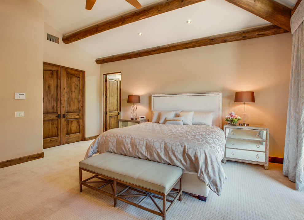На фото: огромная хозяйская спальня в средиземноморском стиле с бежевыми стенами и ковровым покрытием без камина с