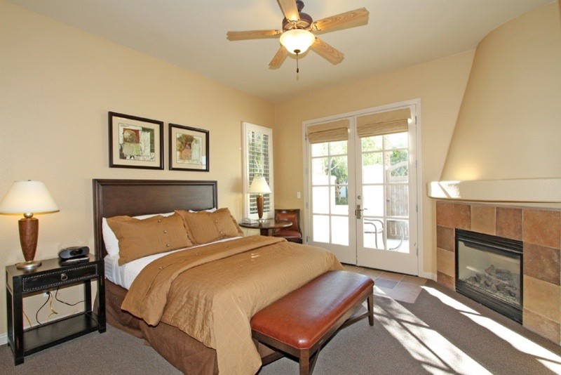 Aménagement d'une chambre classique de taille moyenne avec un mur beige, une cheminée standard, un manteau de cheminée en carrelage et un sol gris.