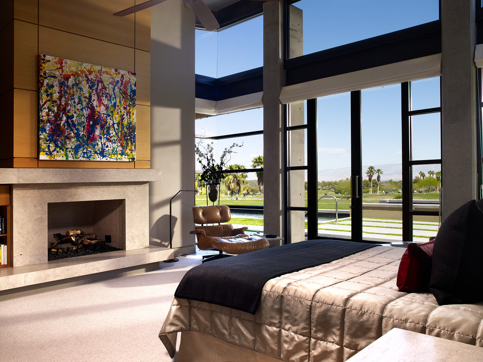 На фото: спальня в современном стиле с ковровым покрытием, стандартным камином и фасадом камина из камня с