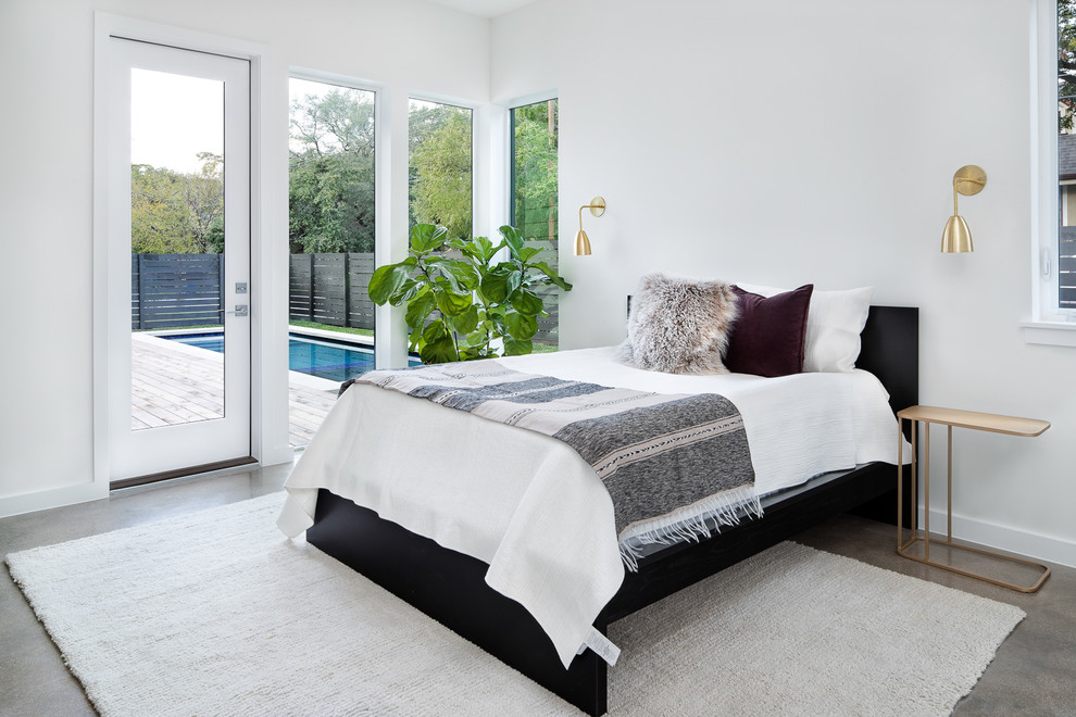 Ejemplo de habitación de invitados retro de tamaño medio sin chimenea con paredes blancas, suelo de cemento y suelo gris