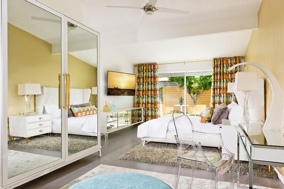 Retro Hauptschlafzimmer ohne Kamin mit gelber Wandfarbe und grauem Boden in Los Angeles