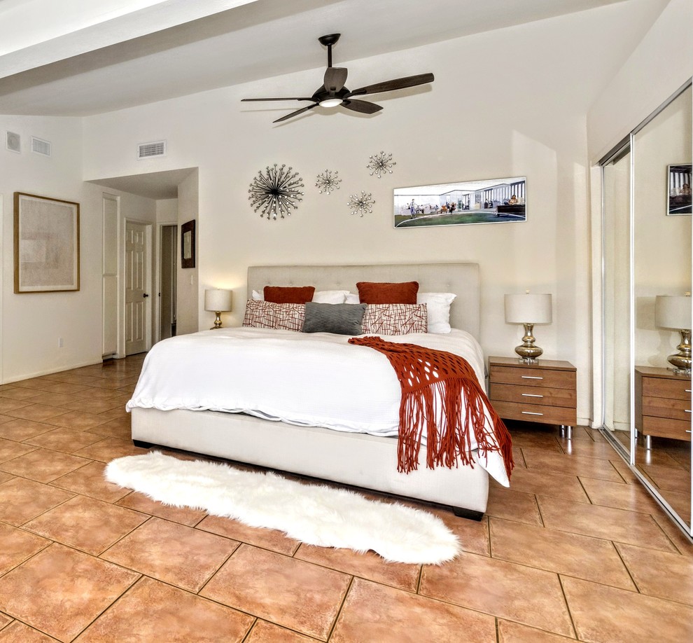 Modelo de dormitorio principal contemporáneo grande sin chimenea con paredes beige, suelo de baldosas de cerámica y suelo marrón