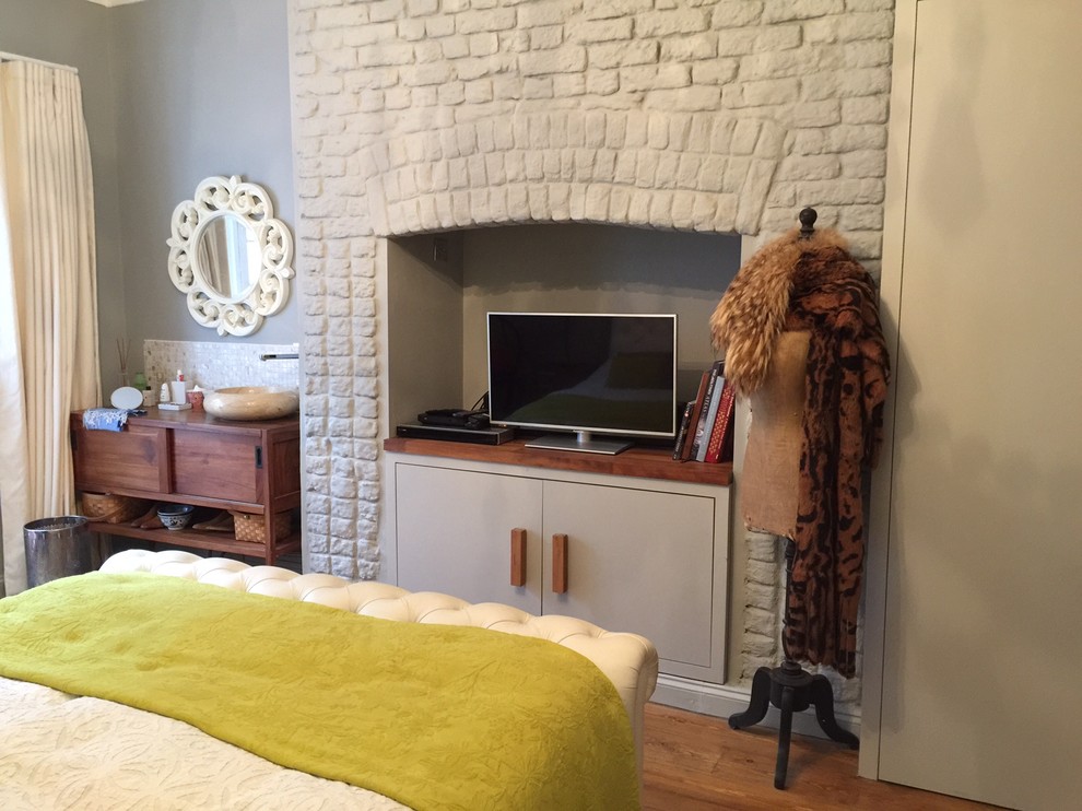 サセックスにある中くらいなトランジショナルスタイルのおしゃれな客用寝室 (濃色無垢フローリング、レンガの暖炉まわり)