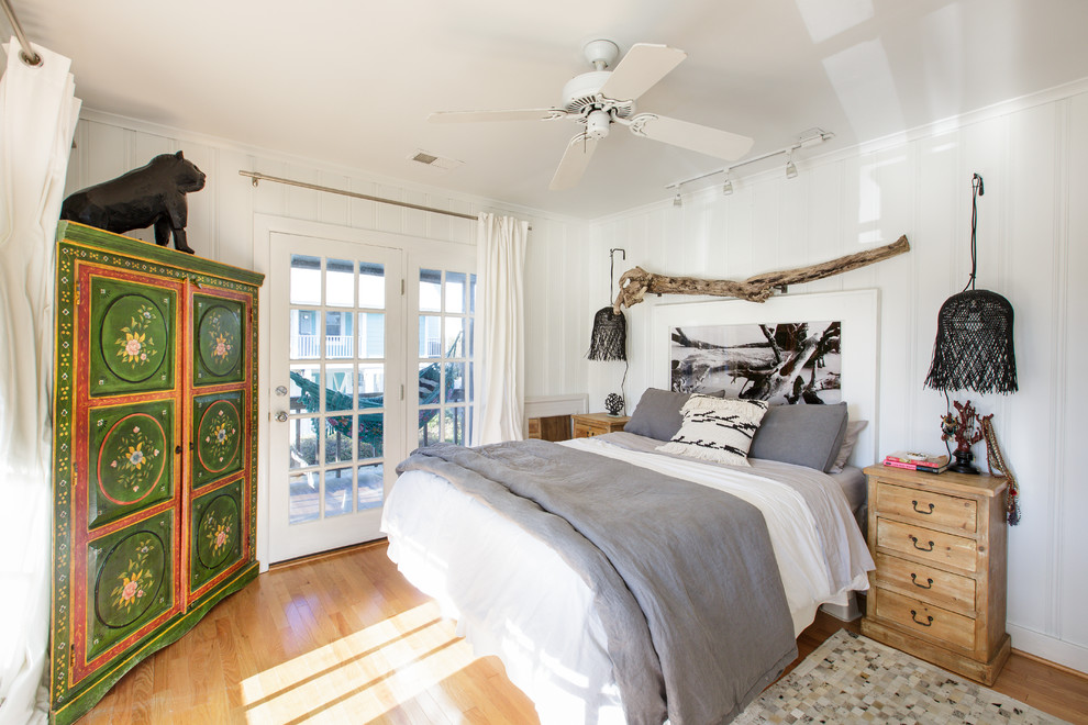 Maritimes Schlafzimmer mit weißer Wandfarbe, hellem Holzboden und beigem Boden in Sonstige