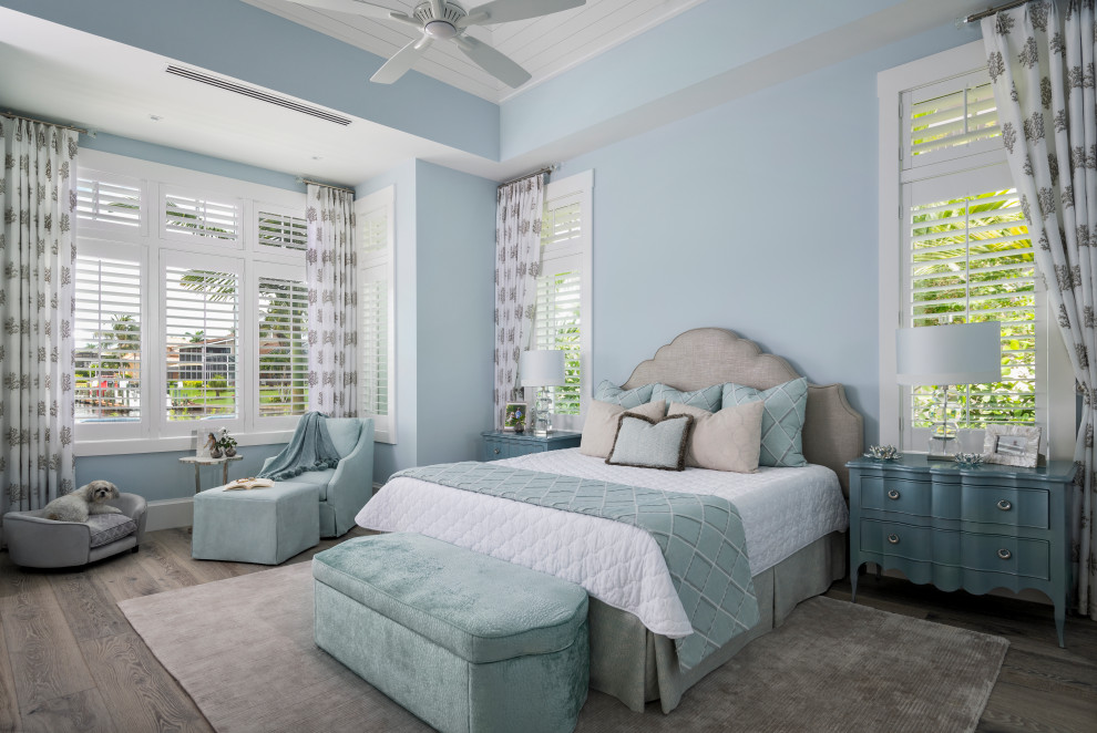 Maritimes Hauptschlafzimmer mit blauer Wandfarbe, braunem Holzboden, braunem Boden, gewölbter Decke und Holzdielenwänden in Sonstige