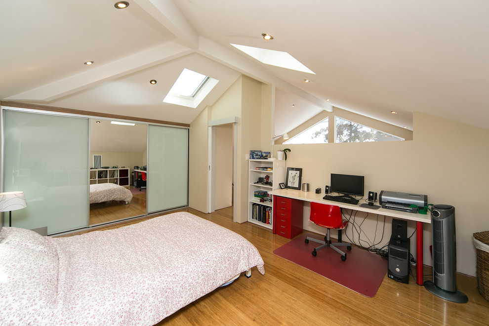 Imagen de dormitorio tipo loft moderno de tamaño medio con suelo de bambú