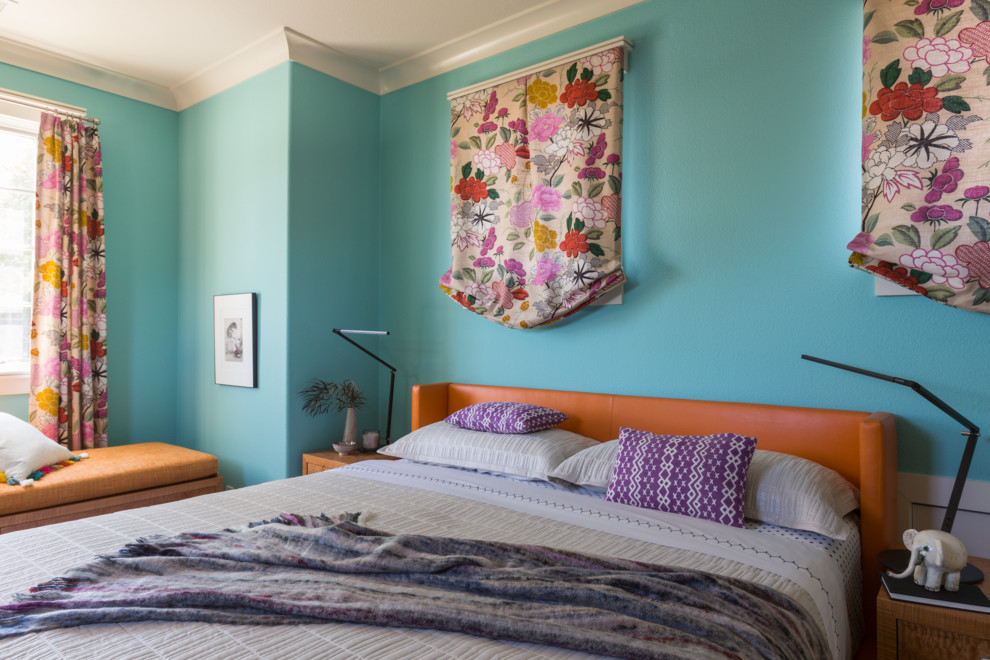 Idée de décoration pour une petite chambre parentale design avec un mur bleu et parquet foncé.