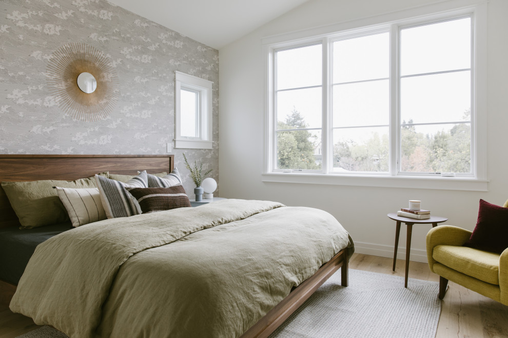 Cette image montre une chambre parentale traditionnelle de taille moyenne avec un mur blanc, un sol en bois brun, aucune cheminée, un sol marron, un plafond voûté et du papier peint.