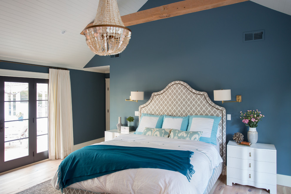 Immagine di una camera da letto tradizionale con pareti blu e parquet chiaro