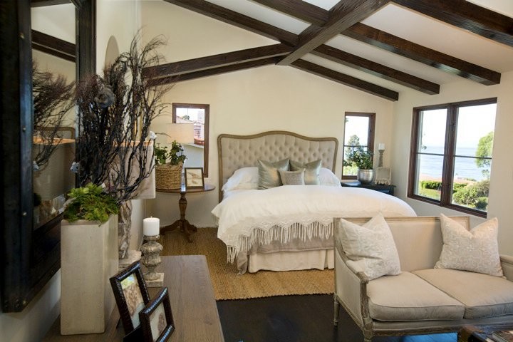 На фото: хозяйская спальня среднего размера в стиле кантри с белыми стенами, темным паркетным полом и коричневым полом с