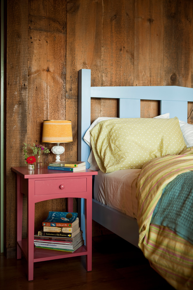 This is an example of a rustic bedroom in Portland Maine with brown floors.