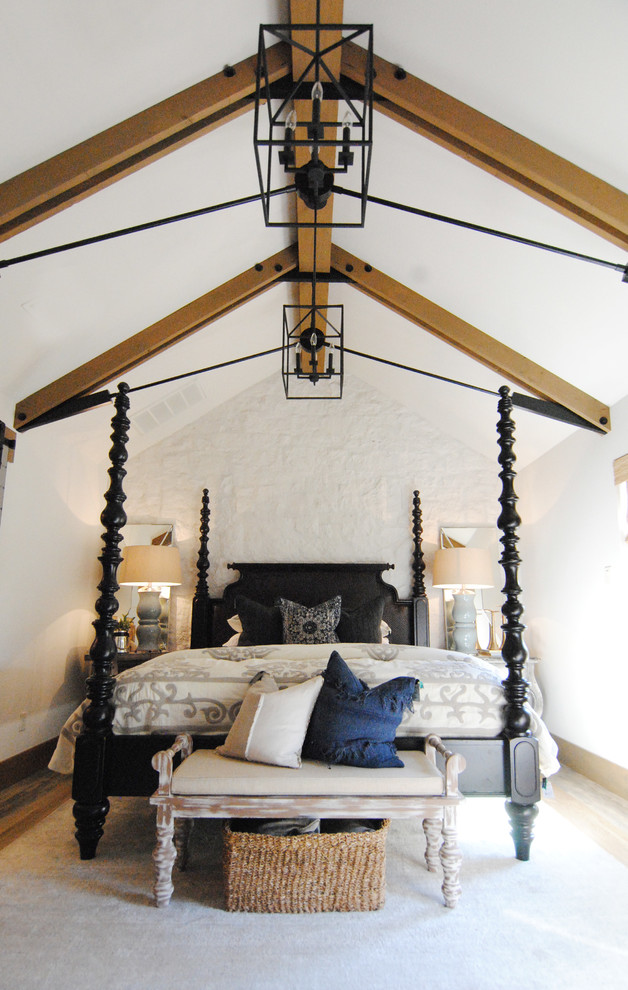 Diseño de dormitorio principal ecléctico grande con paredes blancas, suelo vinílico, chimenea de esquina, marco de chimenea de piedra y suelo marrón