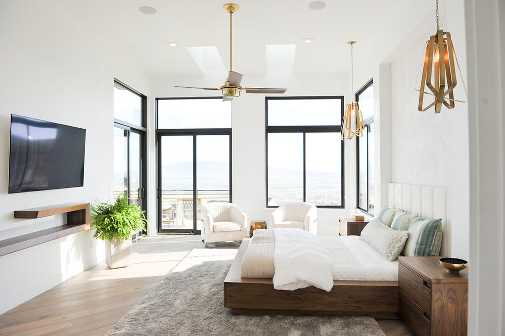 Foto de dormitorio actual con paredes blancas, suelo de madera clara y suelo beige
