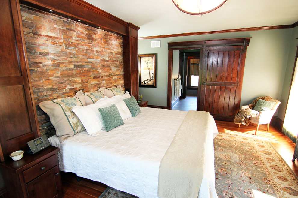 Imagen de dormitorio principal de estilo de casa de campo grande sin chimenea con suelo de madera en tonos medios y paredes verdes
