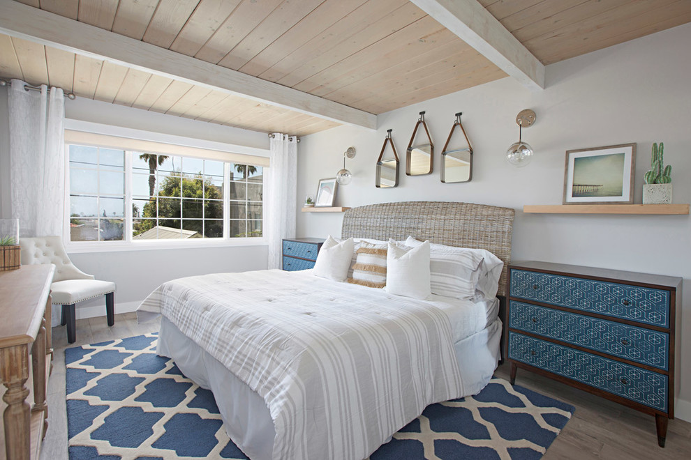 Design ideas for a medium sized coastal guest bedroom in San Diego with grey walls, vinyl flooring and brown floors.