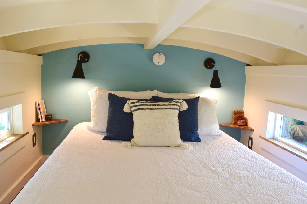 На фото: маленькая спальня на антресоли в морском стиле с синими стенами и полом из ламината для на участке и в саду