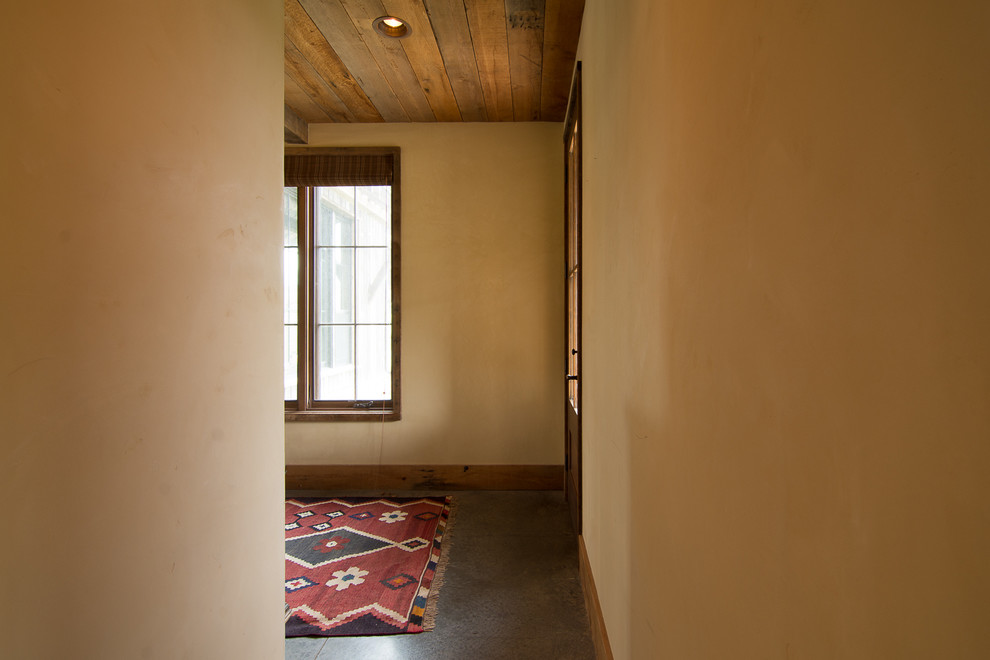 На фото: гостевая спальня среднего размера, (комната для гостей) в стиле фьюжн с бежевыми стенами, бетонным полом и серым полом без камина