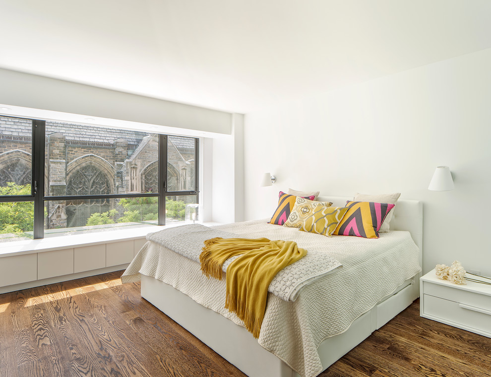 Mittelgroßes Modernes Schlafzimmer mit weißer Wandfarbe, braunem Holzboden und braunem Boden in New York
