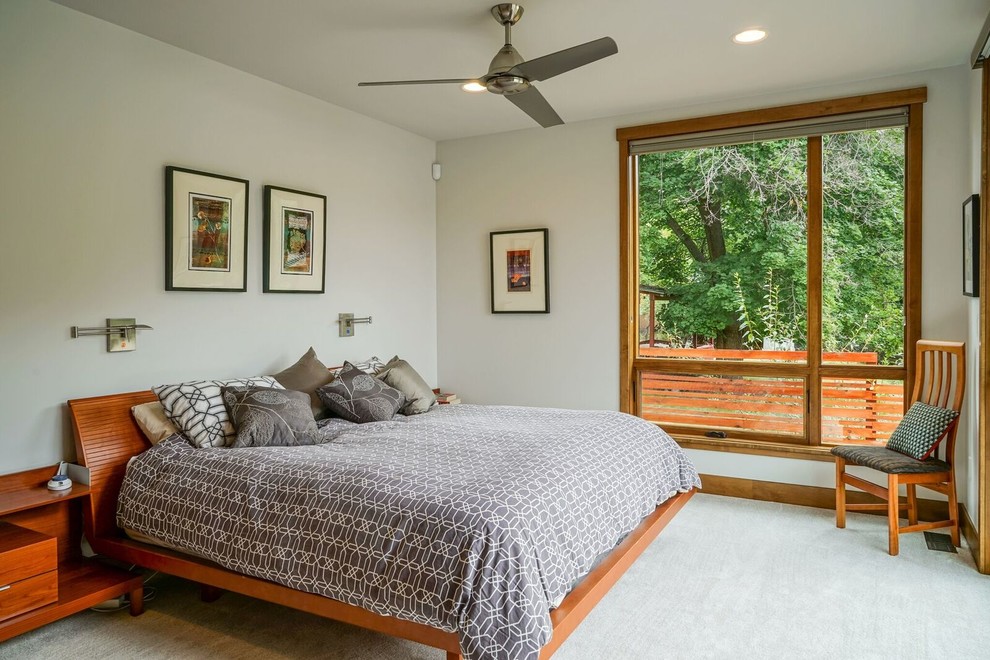 This is an example of a medium sized contemporary master bedroom in Denver with white walls, carpet, no fireplace and grey floors.