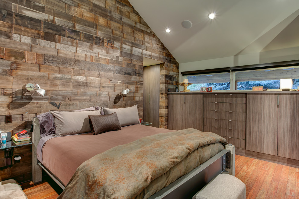 Modelo de dormitorio contemporáneo sin chimenea con suelo de madera en tonos medios