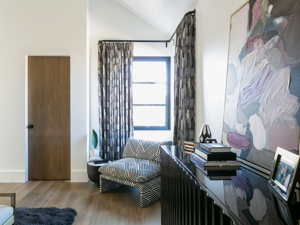Diseño de habitación de invitados grande con paredes blancas, suelo de madera en tonos medios y suelo marrón