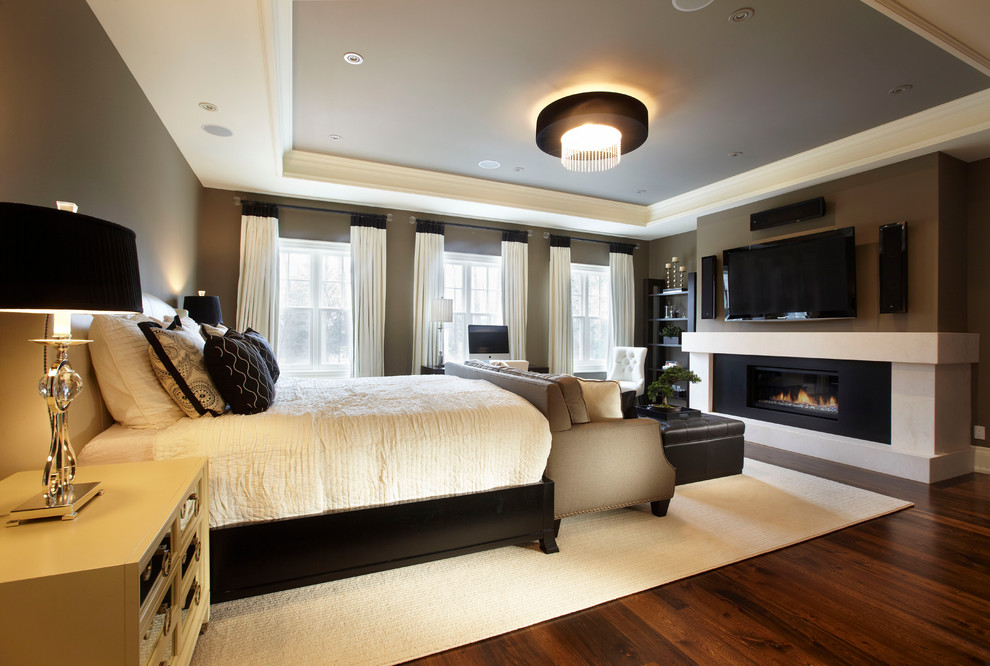 Свежая идея для дизайна: большая хозяйская спальня в стиле неоклассика (современная классика) с коричневыми стенами, темным паркетным полом и горизонтальным камином - отличное фото интерьера