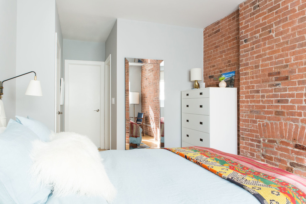 Immagine di una piccola camera matrimoniale minimalista con pareti grigie e parquet chiaro