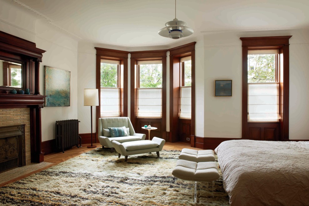 Modernes Hauptschlafzimmer mit weißer Wandfarbe und Kamin in New York