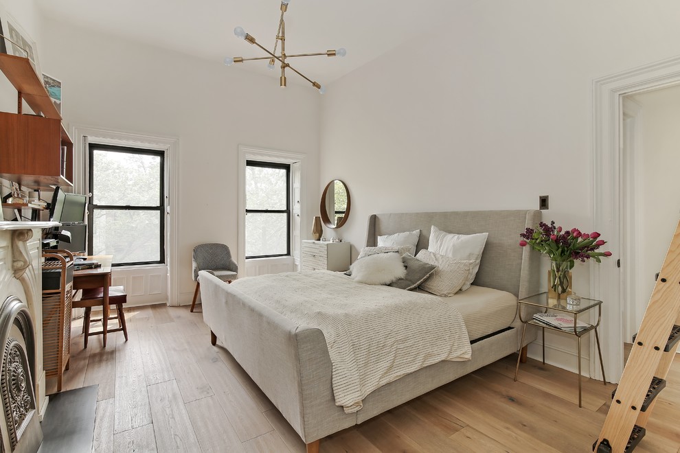 Großes Klassisches Hauptschlafzimmer mit weißer Wandfarbe, hellem Holzboden, beigem Boden, Kamin und verputzter Kaminumrandung in New York