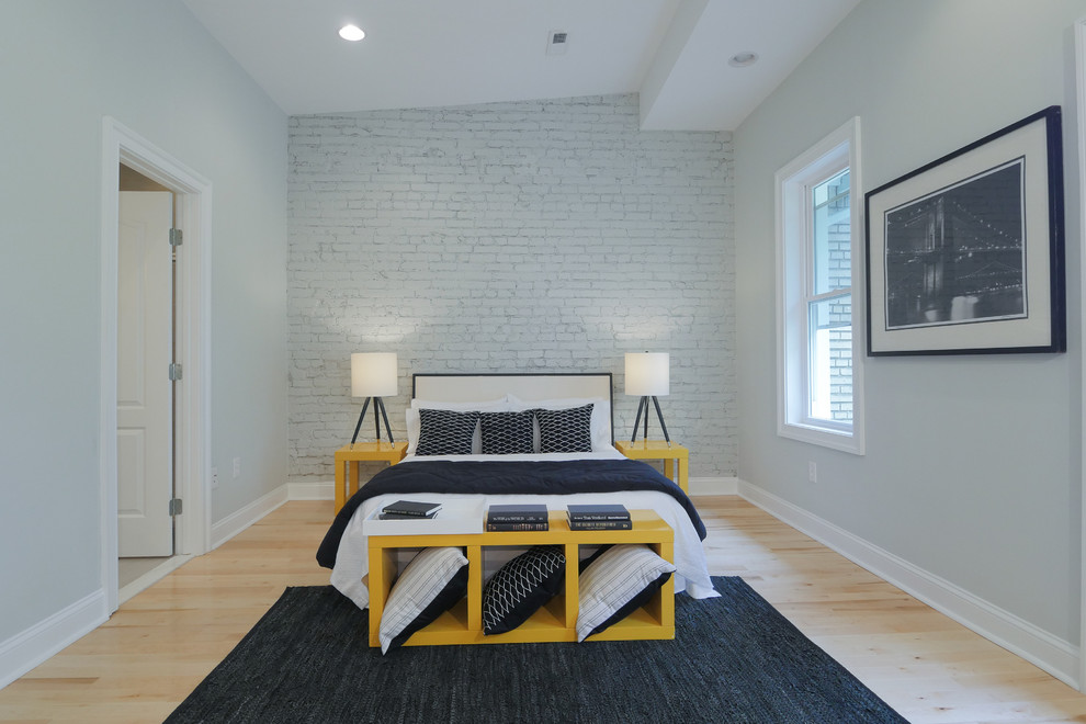 Example of a light wood floor bedroom design in DC Metro with white walls