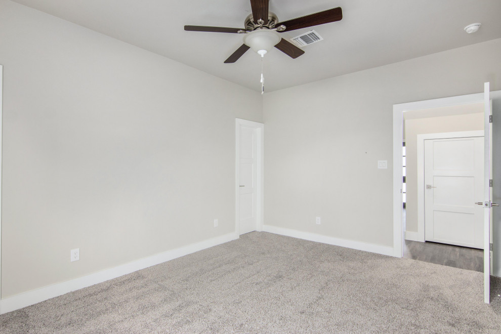 ヒューストンにある広いトランジショナルスタイルのおしゃれな客用寝室 (グレーの壁、カーペット敷き、暖炉なし、グレーの床)