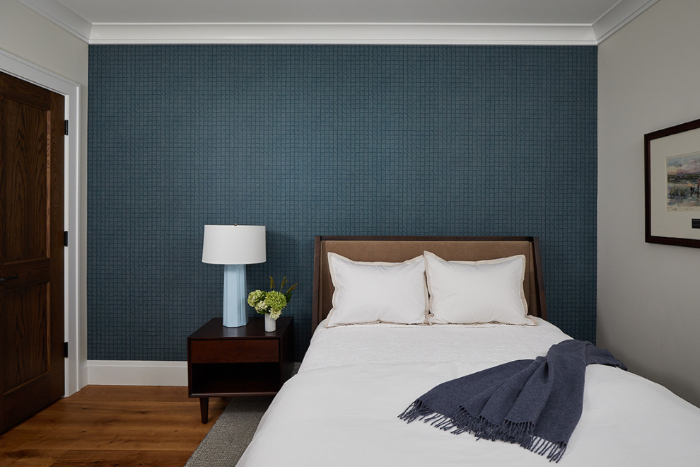 Foto di una camera degli ospiti chic con pareti blu, pavimento in legno massello medio, pavimento marrone e carta da parati