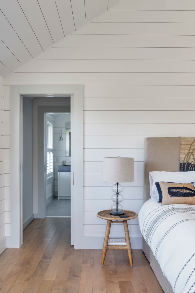 Cette photo montre une chambre parentale rétro de taille moyenne avec un mur blanc, parquet clair et un sol marron.