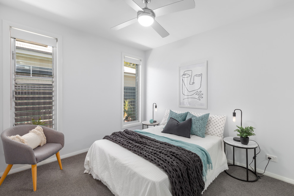 Ejemplo de dormitorio costero con paredes blancas, moqueta y suelo gris