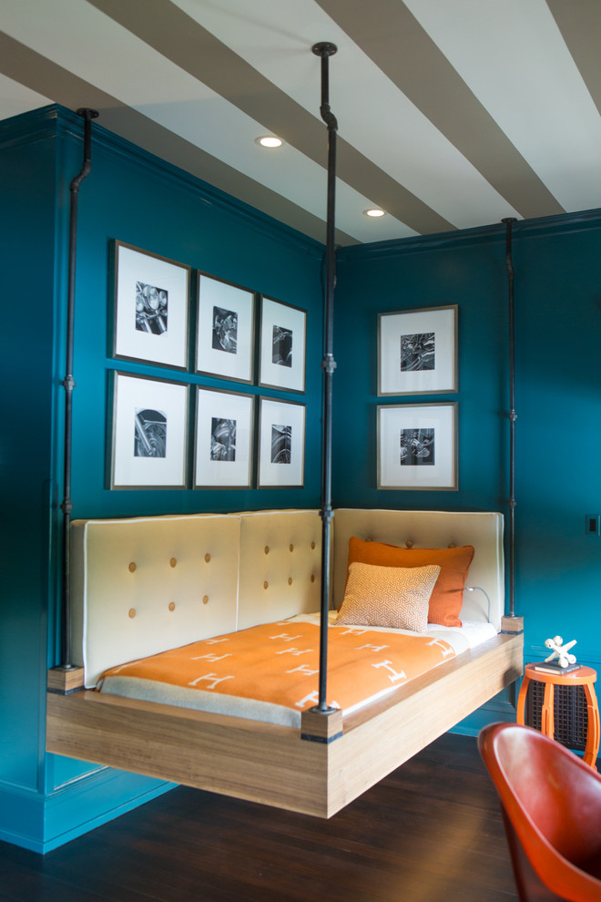 Modelo de habitación de invitados industrial de tamaño medio sin chimenea con paredes azules, suelo de madera oscura y suelo marrón