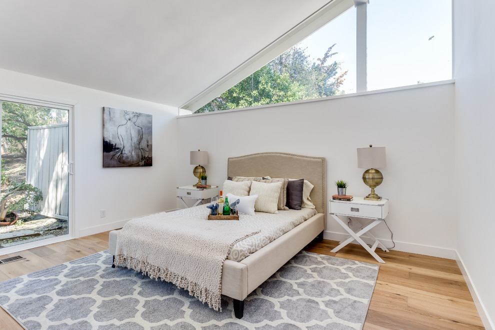 Diseño de dormitorio principal contemporáneo de tamaño medio con paredes blancas y suelo de madera en tonos medios