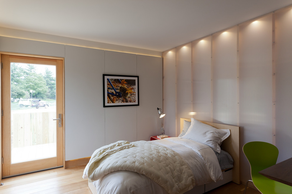 Modelo de dormitorio actual sin chimenea con paredes blancas y suelo de madera clara