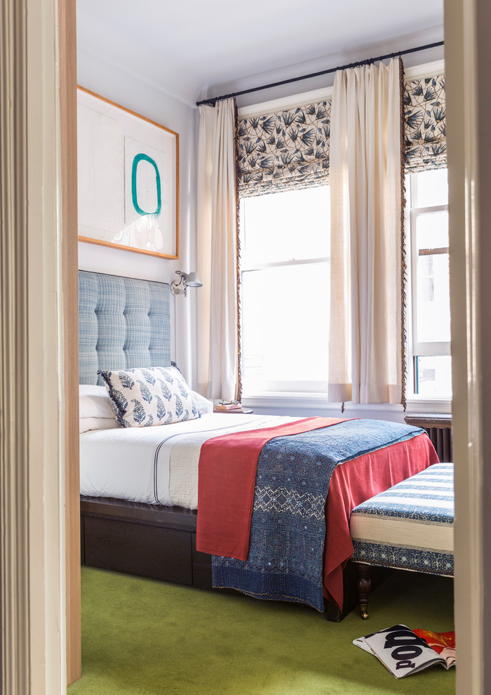 This is an example of a medium sized eclectic guest bedroom in New York with blue walls, carpet, no fireplace and green floors.
