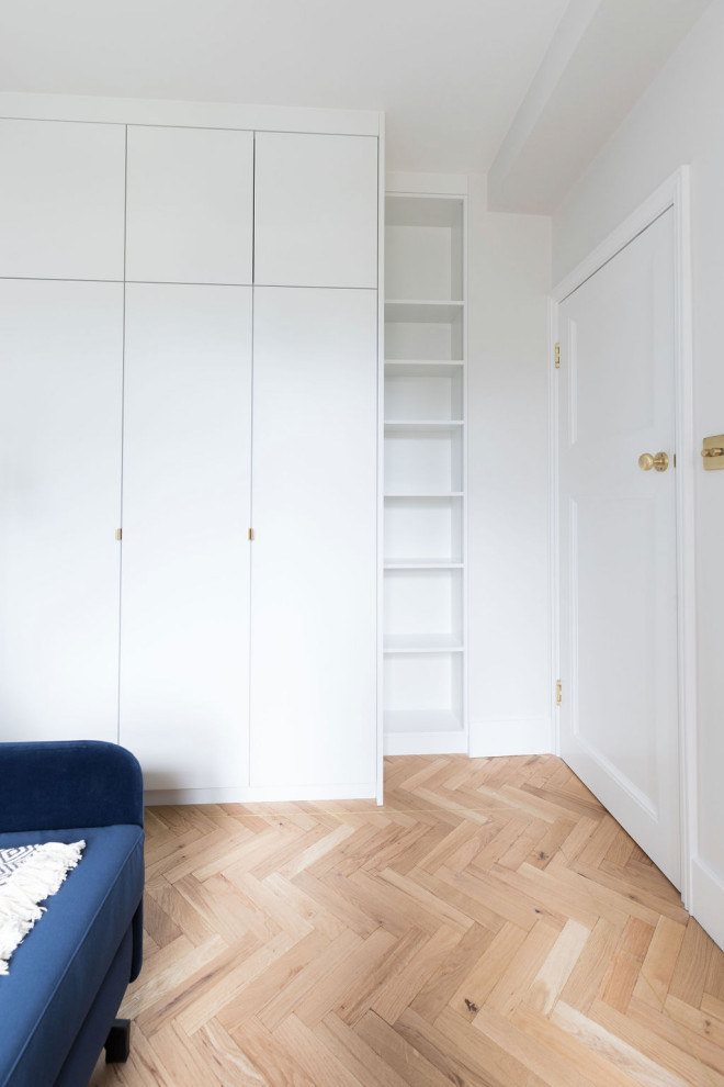 Small trendy master light wood floor and brown floor bedroom photo in London with beige walls