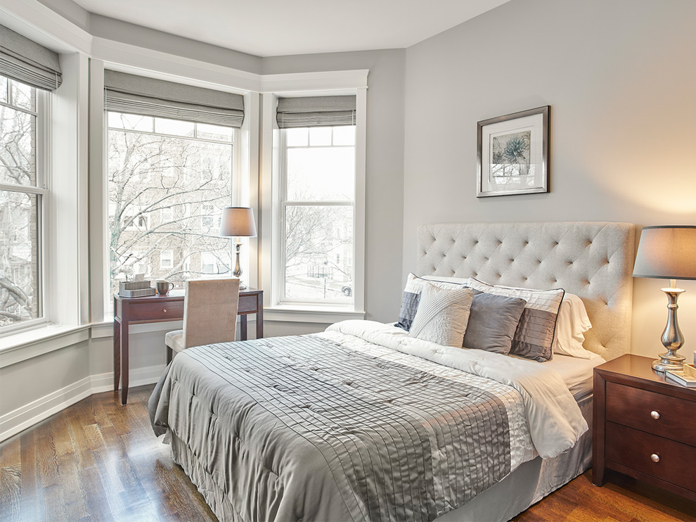 Ejemplo de habitación de invitados gris y blanca tradicional renovada de tamaño medio sin chimenea con paredes grises, suelo de madera en tonos medios y con escritorio